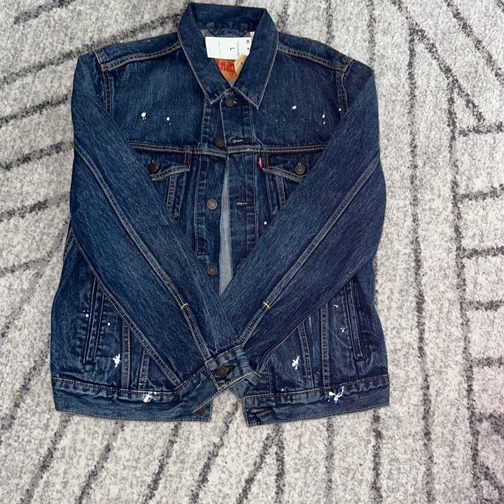 Never worn, NWT men’s Levi’s denim jacket with paint splatter pattern.